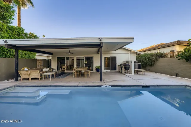 a view of a patio with dining table and chairs