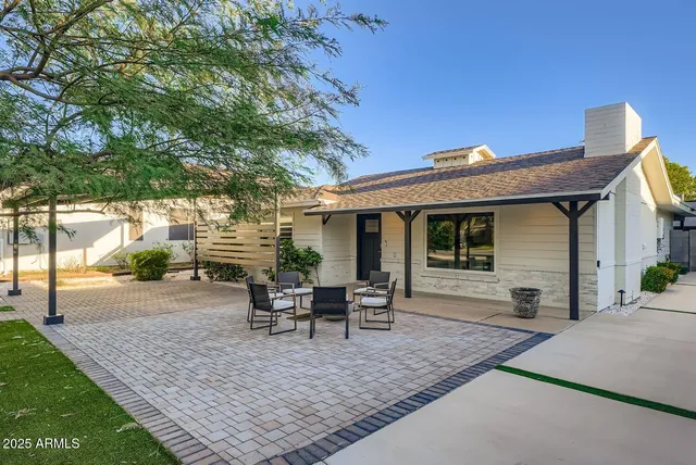 a view of a house with backyard and sitting area