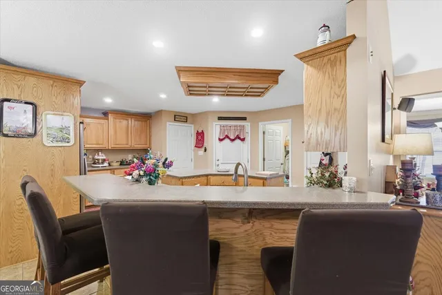 a room with stainless steel appliances kitchen island granite countertop a dining table and chairs