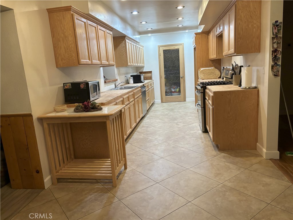 42930 Lake Hughes Road Lake Hughes, CA 93532 - Photo 27 of 54 a kitchen with stainless steel appliances a stove a microwave a sink a refrigerator and cabinets