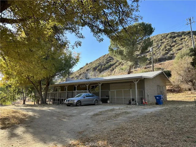 a view of a house with a large tree and front view