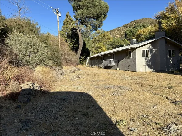 a view of a yard with wooden fence