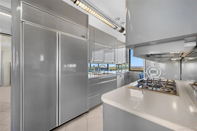 a kitchen with stainless steel appliances granite countertop a refrigerator a sink a stove and white cabinets
