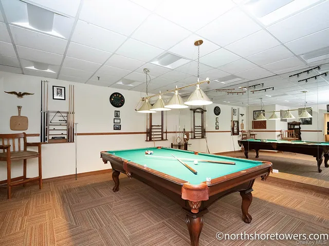 a view of a patio with couches table and chairs under an umbrella with wooden floor