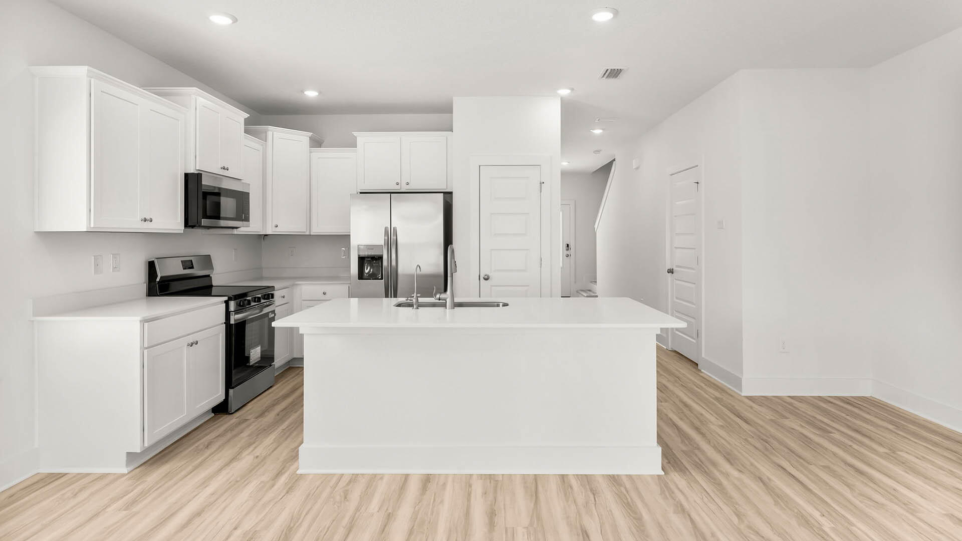 123 Hawk Street Santa Rosa Beach, FL 32459 - Photo 9 of 31 a large white kitchen with kitchen island a sink a stove and a refrigerator