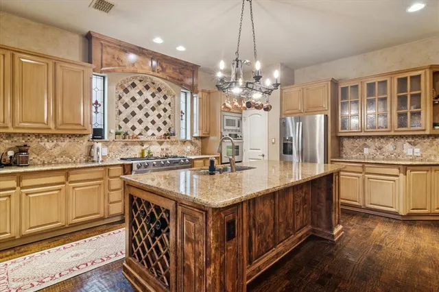 a kitchen with stainless steel appliances granite countertop a sink stove and cabinets