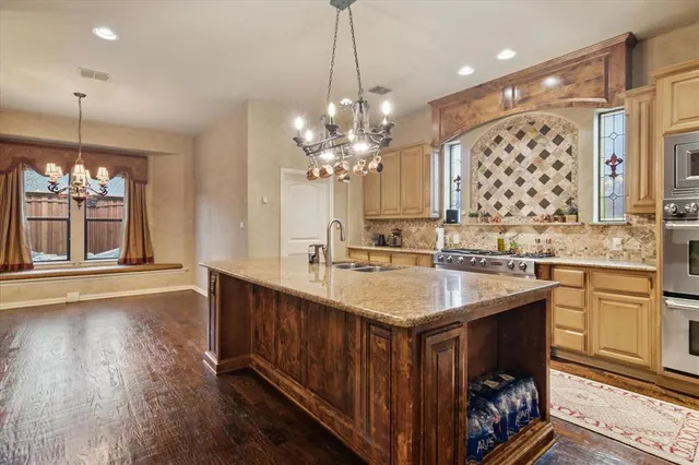 a kitchen with a sink stove and wooden floor