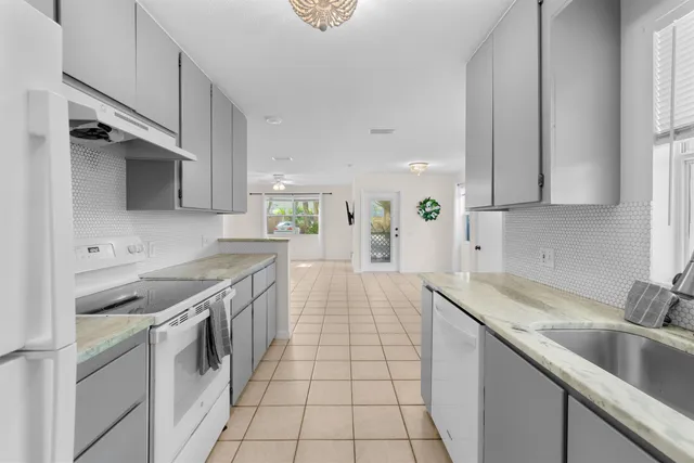 a kitchen with stainless steel appliances granite countertop a sink stove and cabinets