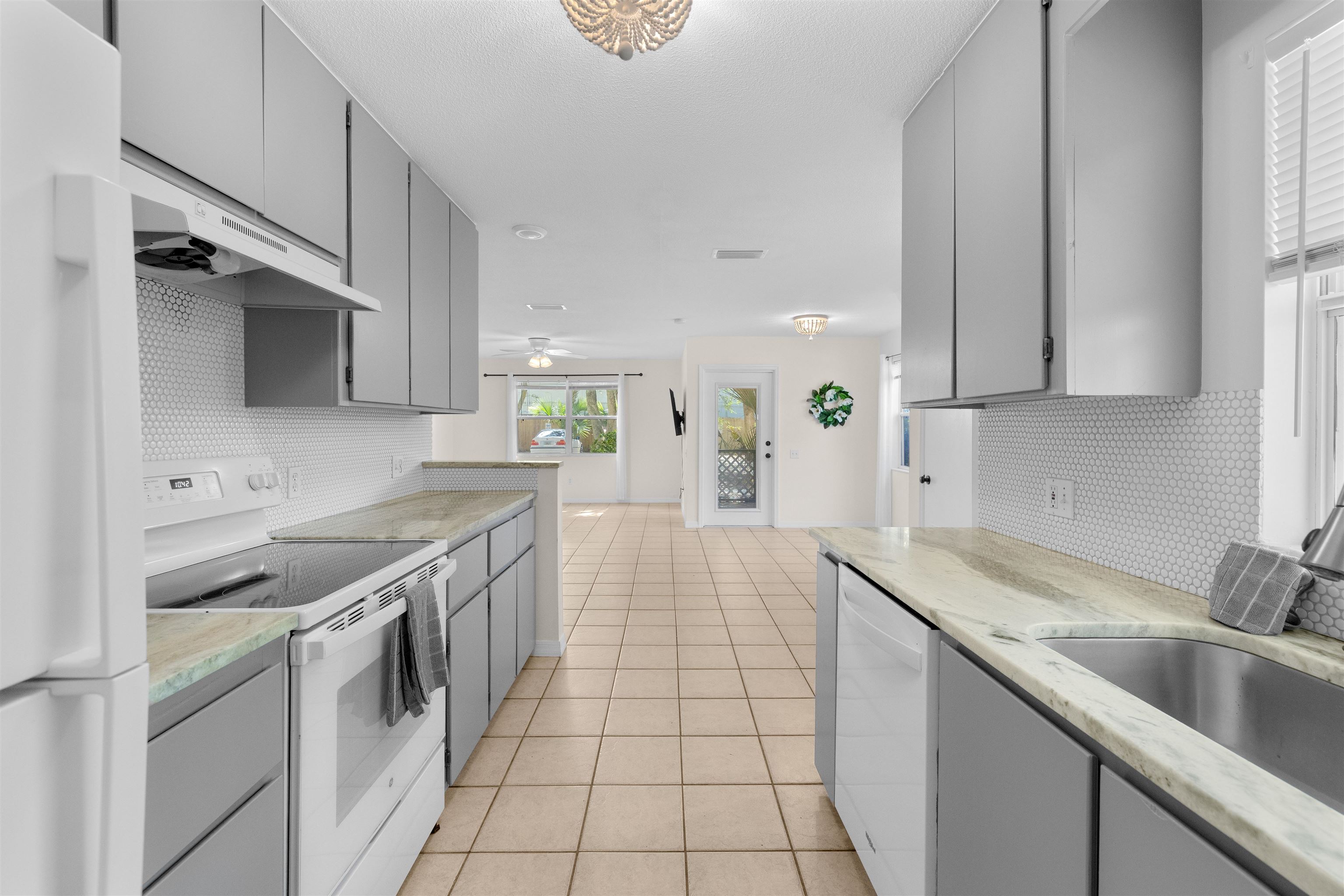 109 B Street, Unit D St. Augustine Beach, FL 32080 - Photo 1 of 29 a kitchen with stainless steel appliances granite countertop a sink stove and cabinets