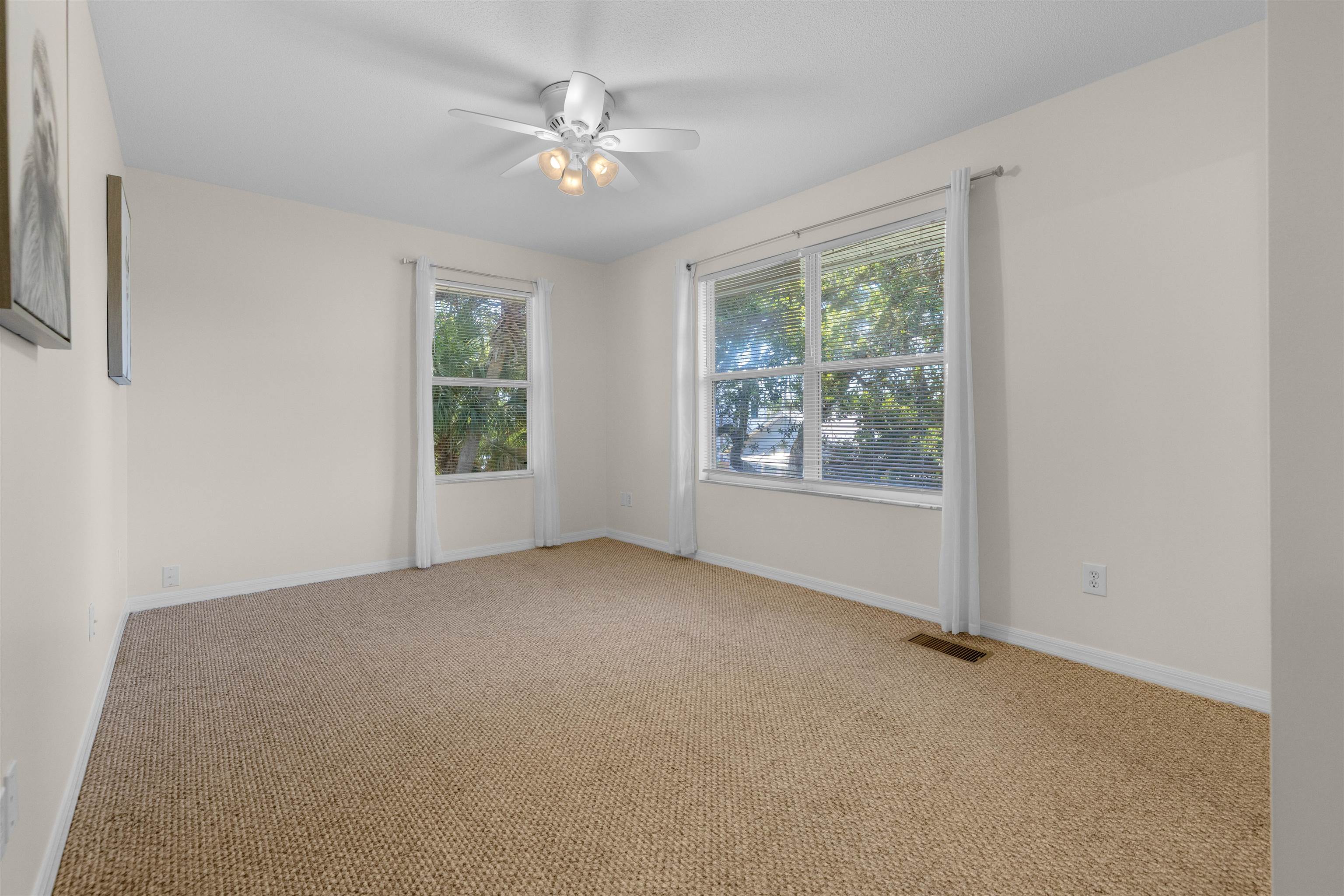109 B Street, Unit D St. Augustine Beach, FL 32080 - Photo 19 of 29 an empty room with windows and chandelier fan