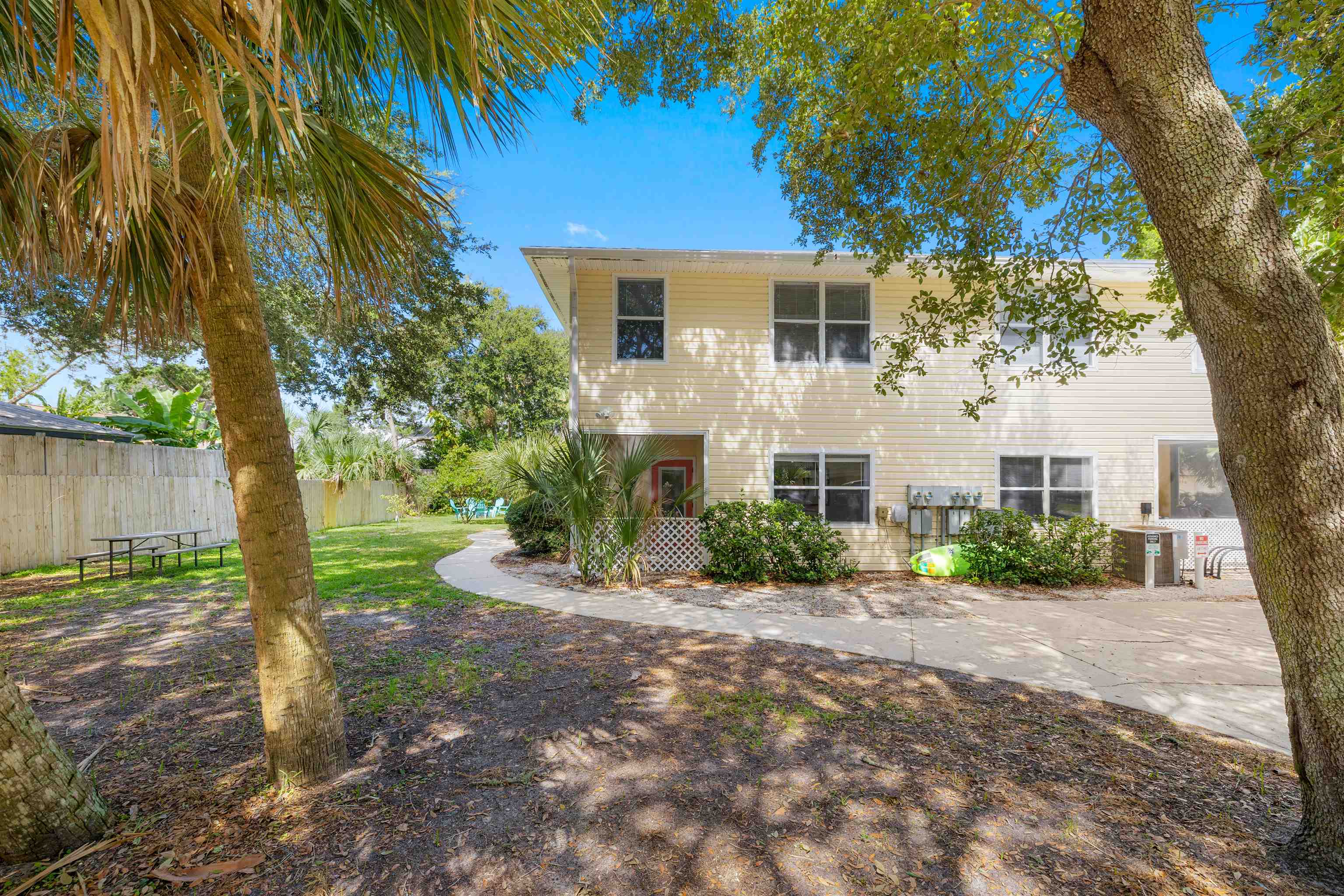 109 B Street, Unit D St. Augustine Beach, FL 32080 - Photo 25 of 29 a front view of a house with a garden and trees