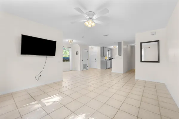 a view of an empty room with a window and a kitchen