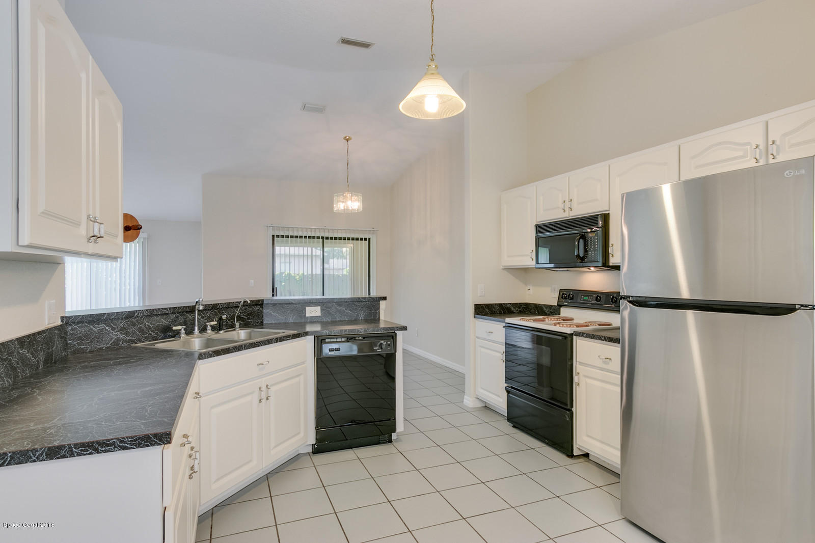 1336 Sapulpa Road Southwest Palm Bay, FL 32908 - Photo 7 of 25 a kitchen with stainless steel appliances granite countertop a stove a sink and a refrigerator