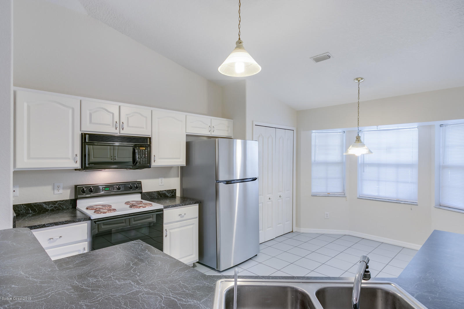 1336 Sapulpa Road Southwest Palm Bay, FL 32908 - Photo 10 of 25 a kitchen with a refrigerator a stove a microwave and island