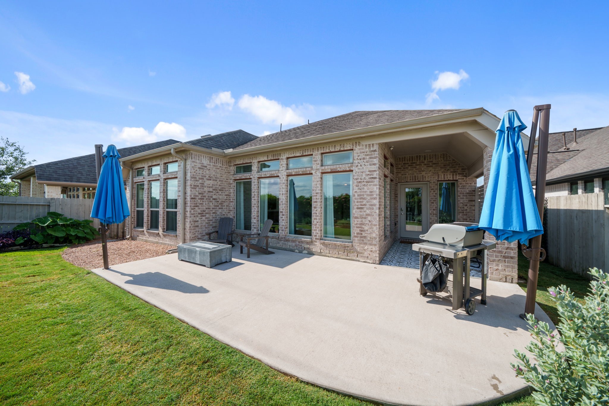 2119 Blackhawk Ridge Lane Manvel, TX 77578 - Photo 34 of 49 Exceptional outdoor living space featuring a covered patio with decorative tile flooring seamlessly extending to a large concrete sitting area — perfect for entertaining, grilling, and relaxing.