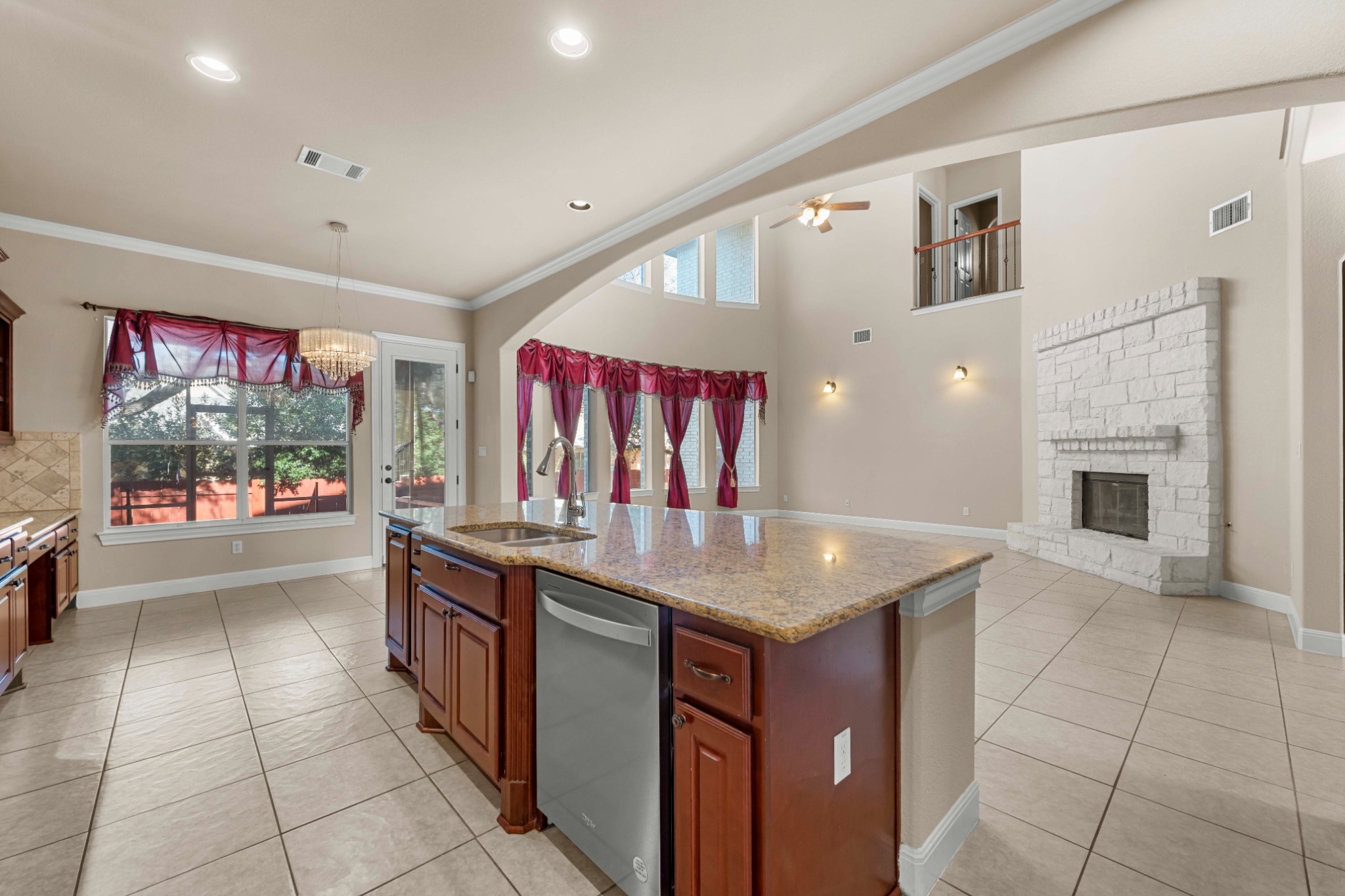 3903 Remington Road Cedar Park, TX 78613 - Photo 9 of 29 A well-lit, open concept kitchen and living area with a beautiful stone fireplace.