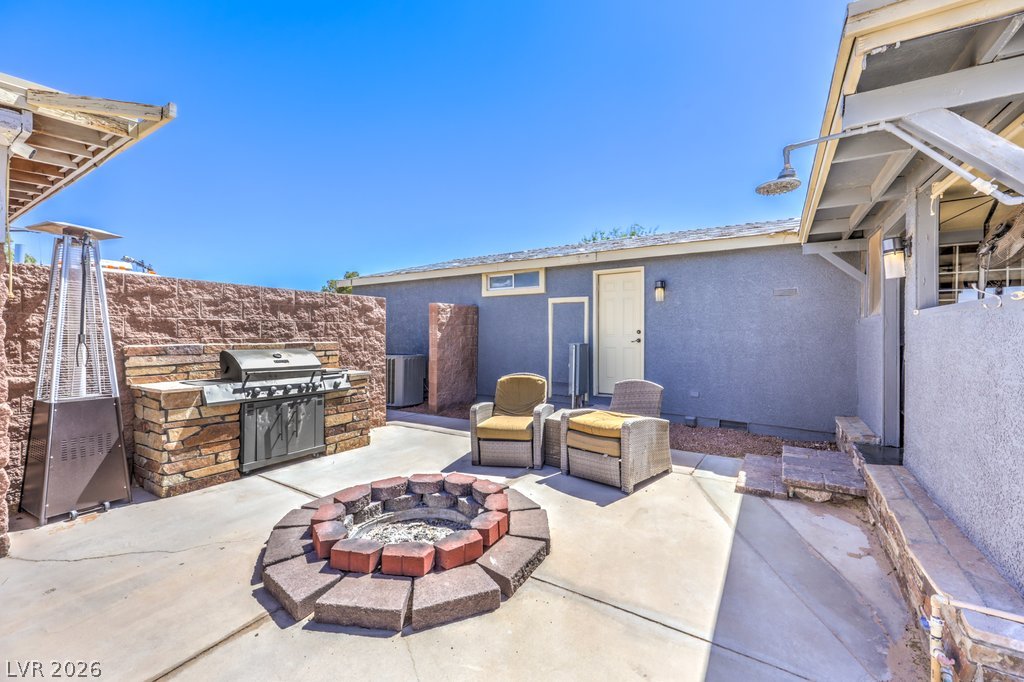 4375 Pinwheel Street Logandale, NV 89021 - Photo 34 of 52 An inviting outdoor space features a built-in barbecue and a cozy fire pit, ideal for entertaining.