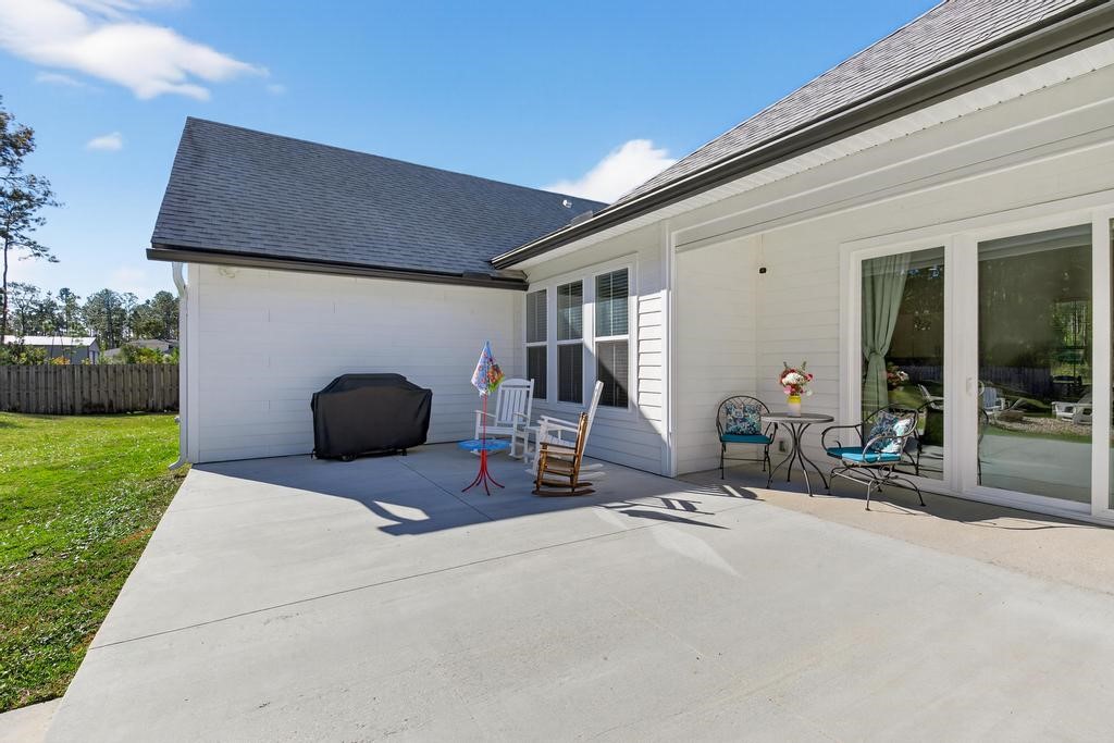 75774 Edwards Road Yulee, FL 32097 - Photo 52 of 70 a view of a patio with a table and chairs under an umbrella