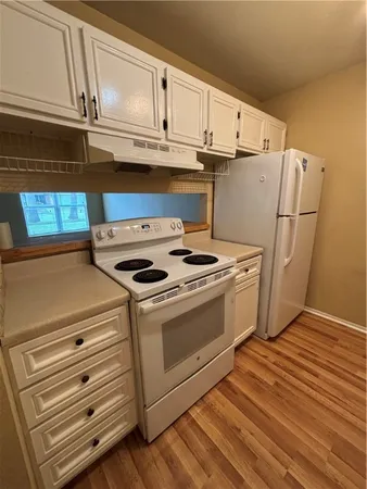 a kitchen with cabinets and steel appliances