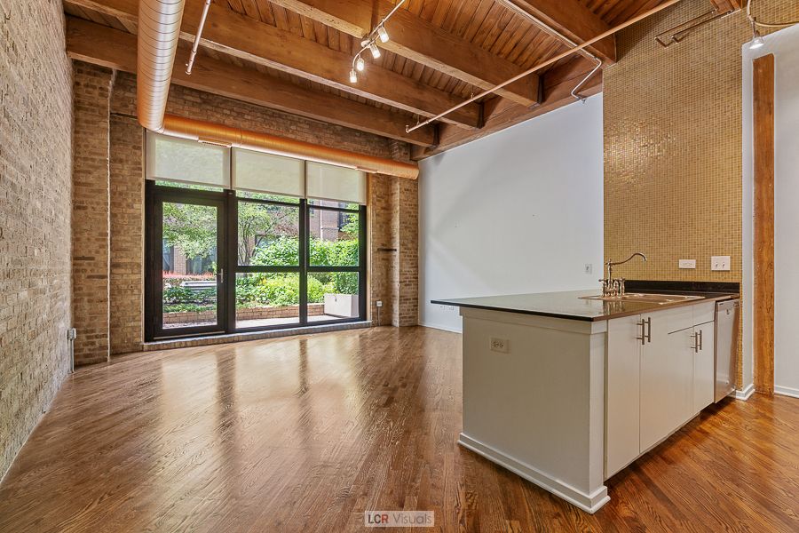 1040 West Adams Street, Unit 247 Chicago, IL 60607 - Photo 7 of 20 a view of a kitchen with wooden floor and a large window