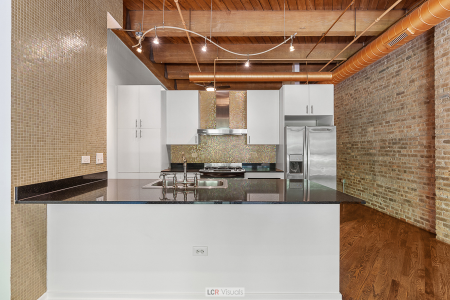 1040 West Adams Street, Unit 247 Chicago, IL 60607 - Photo 8 of 20 a kitchen with stainless steel appliances granite countertop a sink and a refrigerator