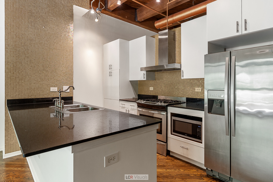 1040 West Adams Street, Unit 247 Chicago, IL 60607 - Photo 9 of 20 a kitchen with stainless steel appliances granite countertop a sink a stove and refrigerator