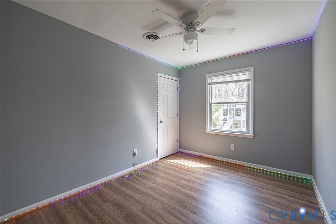 9813 Colemans Lake Road Ford, VA 23850 - Photo 24 of 38 an empty room with wooden floor and windows