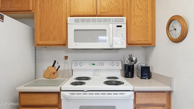 a kitchen with a white cabinets and white appliances
