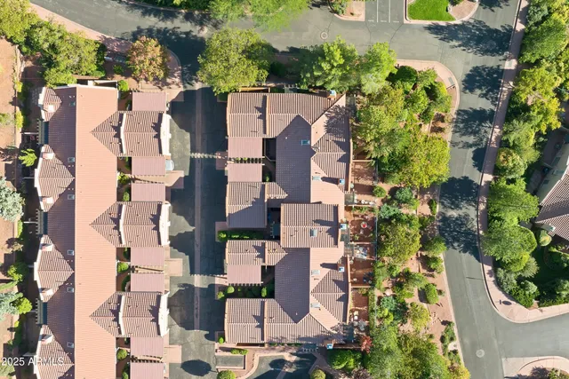 an aerial view of residential houses with outdoor space and trees