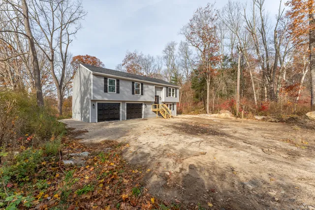 a front view of a house with a yard covered with snow