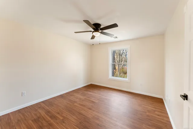 a view of a big room with wooden floor closet and ceiling fan