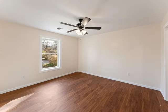 a view of empty room with wooden floor