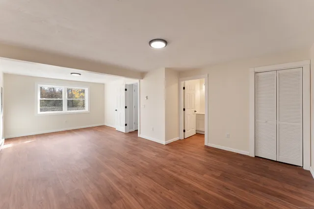 a view of a big room with wooden floor and windows
