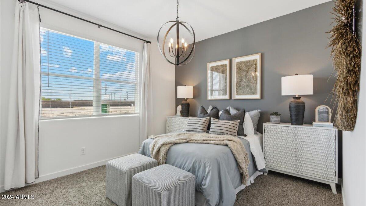 1126 South Mulberry Street Florence, AZ 85132 - Photo 13 of 21 a bedroom with bed a chandelier and a window