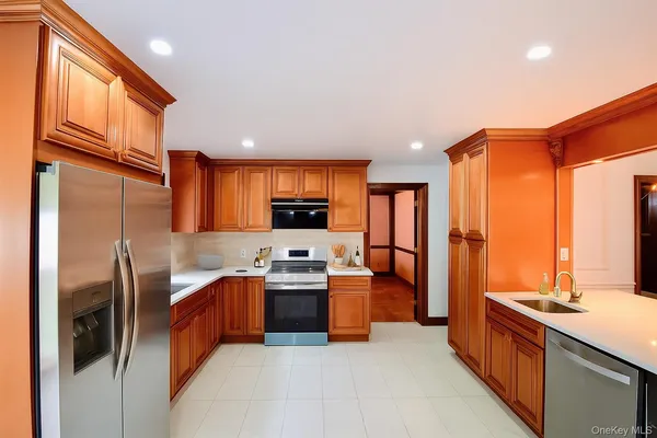 a kitchen with stainless steel appliances granite countertop a sink stove refrigerator and cabinets