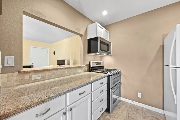 a spacious bathroom with a granite countertop sink and a mirror