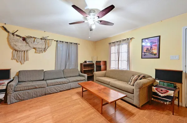 a living room with furniture a ceiling fan and a rug