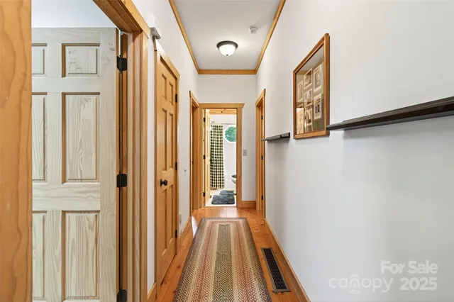 a view of a hallway with wooden floor and staircase