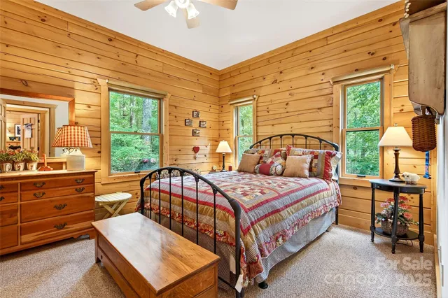 a bedroom with a bed a large window with table and chairs