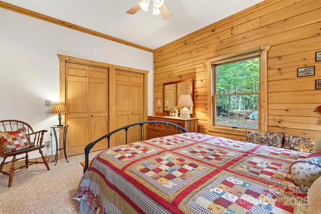 a bedroom with a bed a stove and a large window