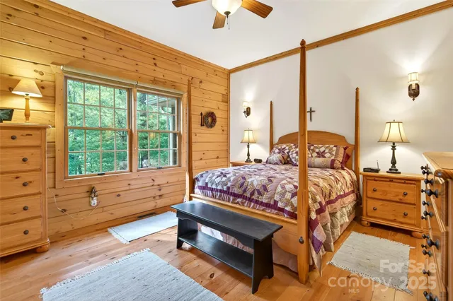 a bedroom with a bed a chandelier and a large window