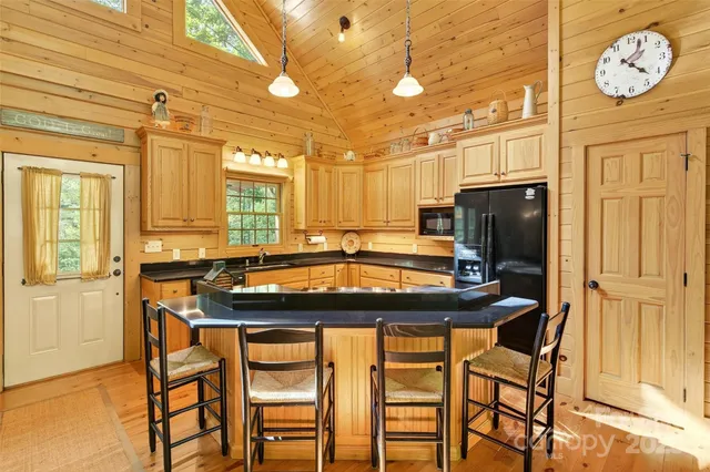 a kitchen with a table chairs refrigerator and cabinets