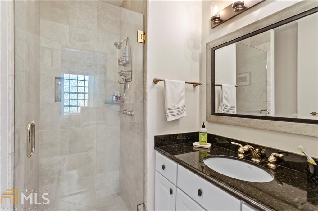 1 South Prado Northeast, Unit 5 Atlanta, GA 30309 - Photo 20 of 33 a bathroom with a granite countertop shower a sink and a mirror