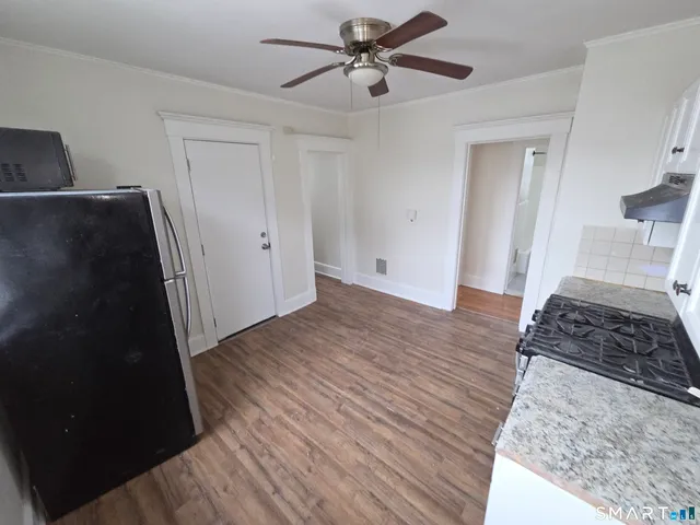 a view of a bedroom with wooden floor and a ceiling fan
