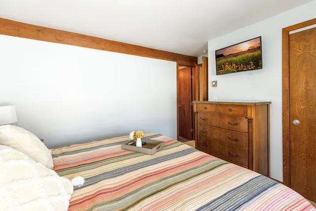 a bedroom with a bed and a painting on the wall