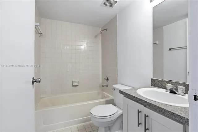 a bathroom with a granite countertop sink toilet mirror and shower