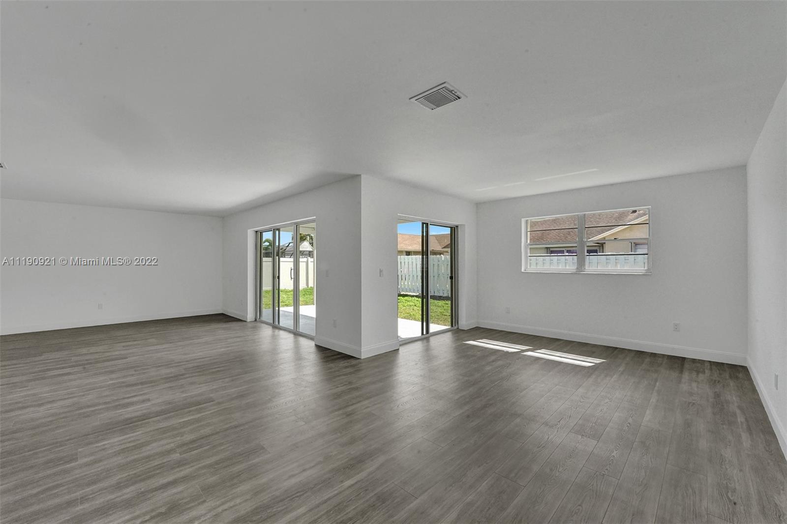 23098 Southwest 55th Avenue Boca Raton, FL 33433 - Photo 11 of 49 an empty room with wooden floor and windows