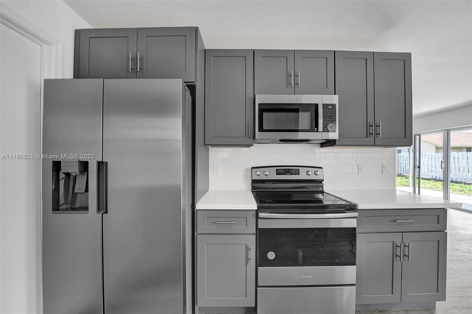23098 Southwest 55th Avenue Boca Raton, FL 33433 - Photo 16 of 49 a kitchen with cabinets stainless steel appliances and counter space