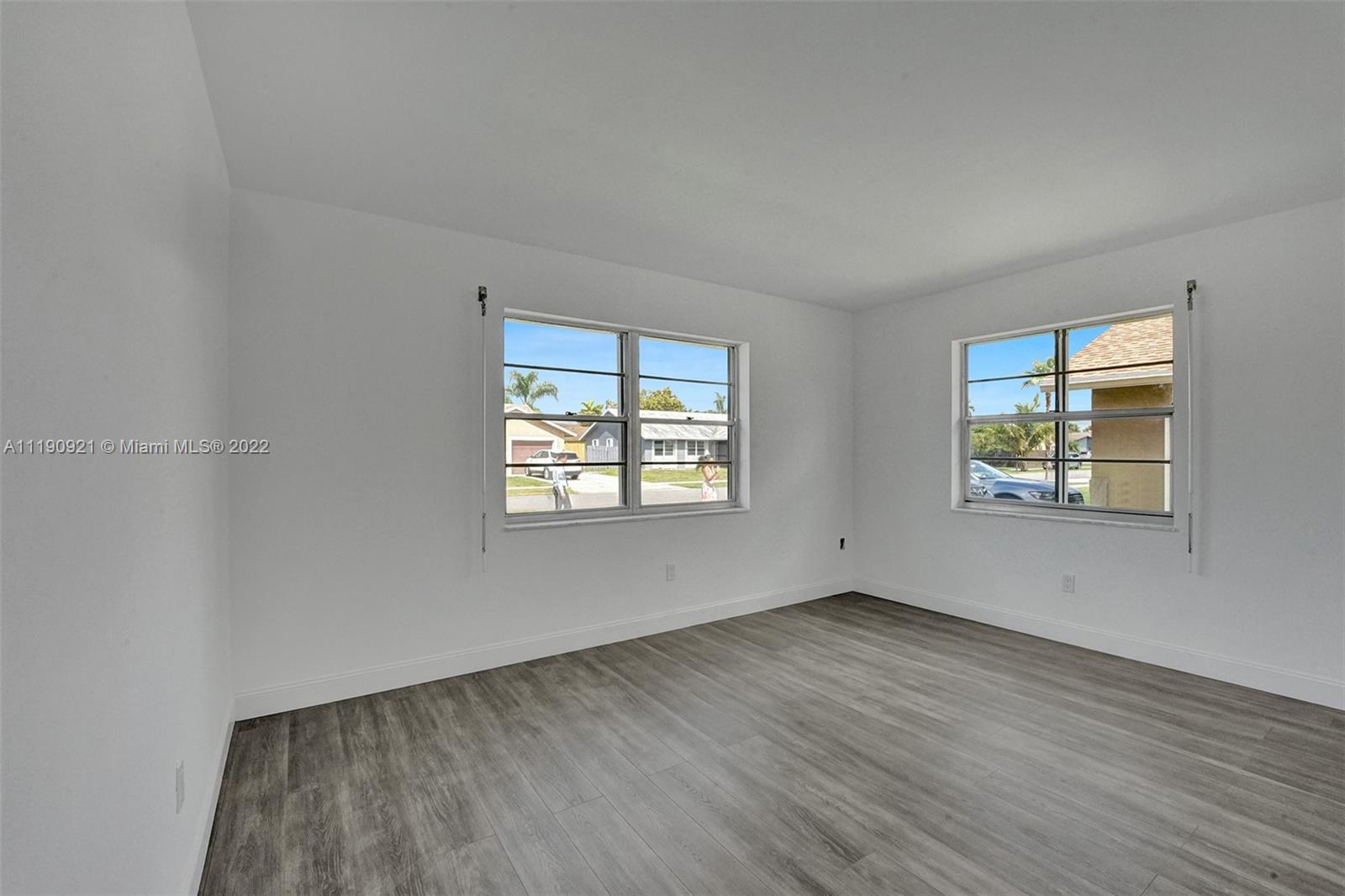 23098 Southwest 55th Avenue Boca Raton, FL 33433 - Photo 19 of 49 an empty room with wooden floor and windows