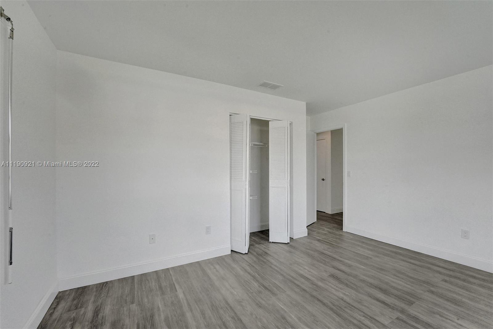 23098 Southwest 55th Avenue Boca Raton, FL 33433 - Photo 21 of 49 a view of an empty room with wooden floor and closet
